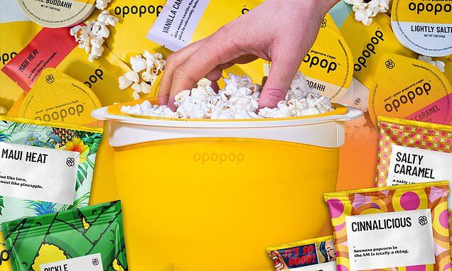 Hand reaching into a yellow popcorn bowl surrounded by colorful snack packages.