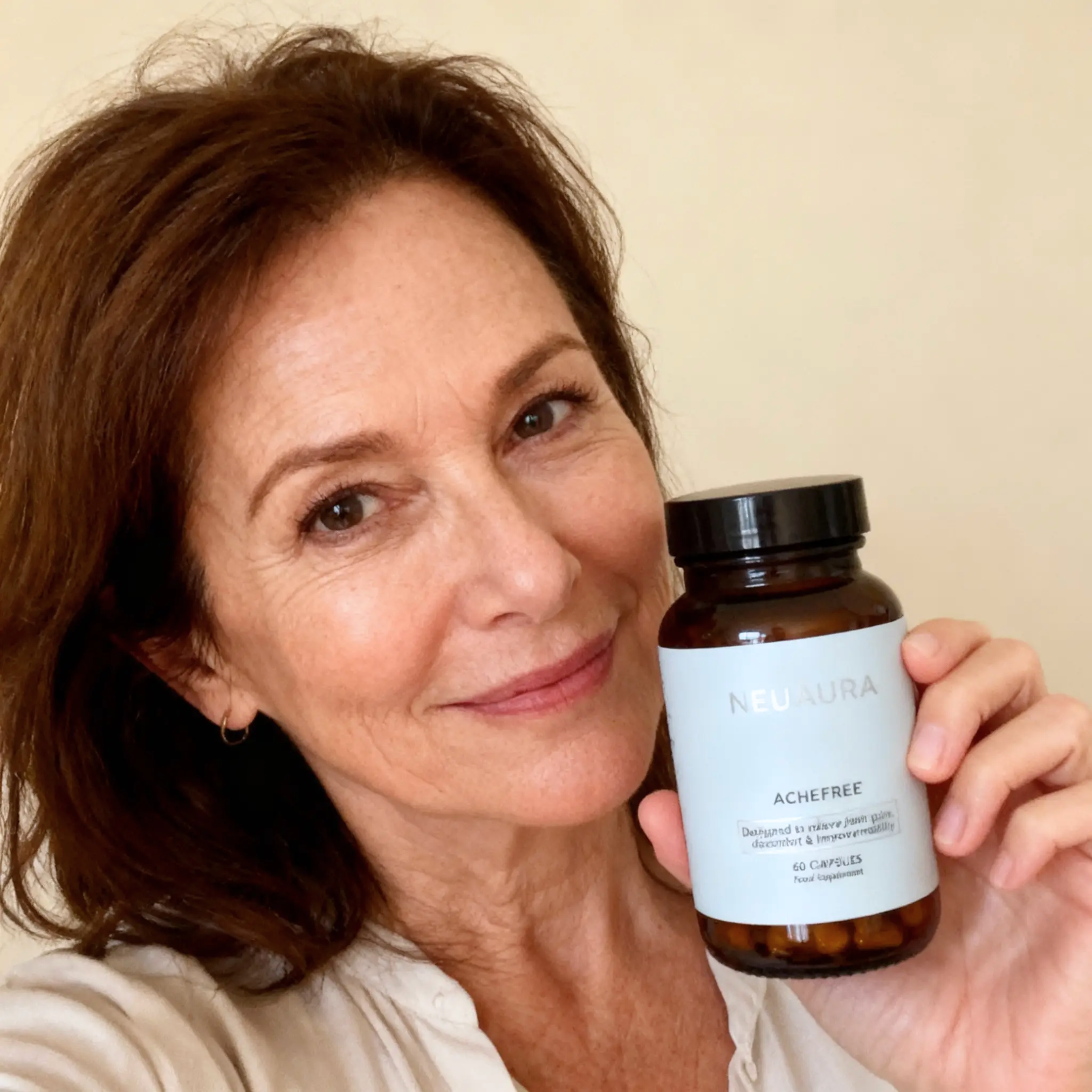 Person holding a bottle labeled 'NEUAURA ACHEFREE' with a smile.