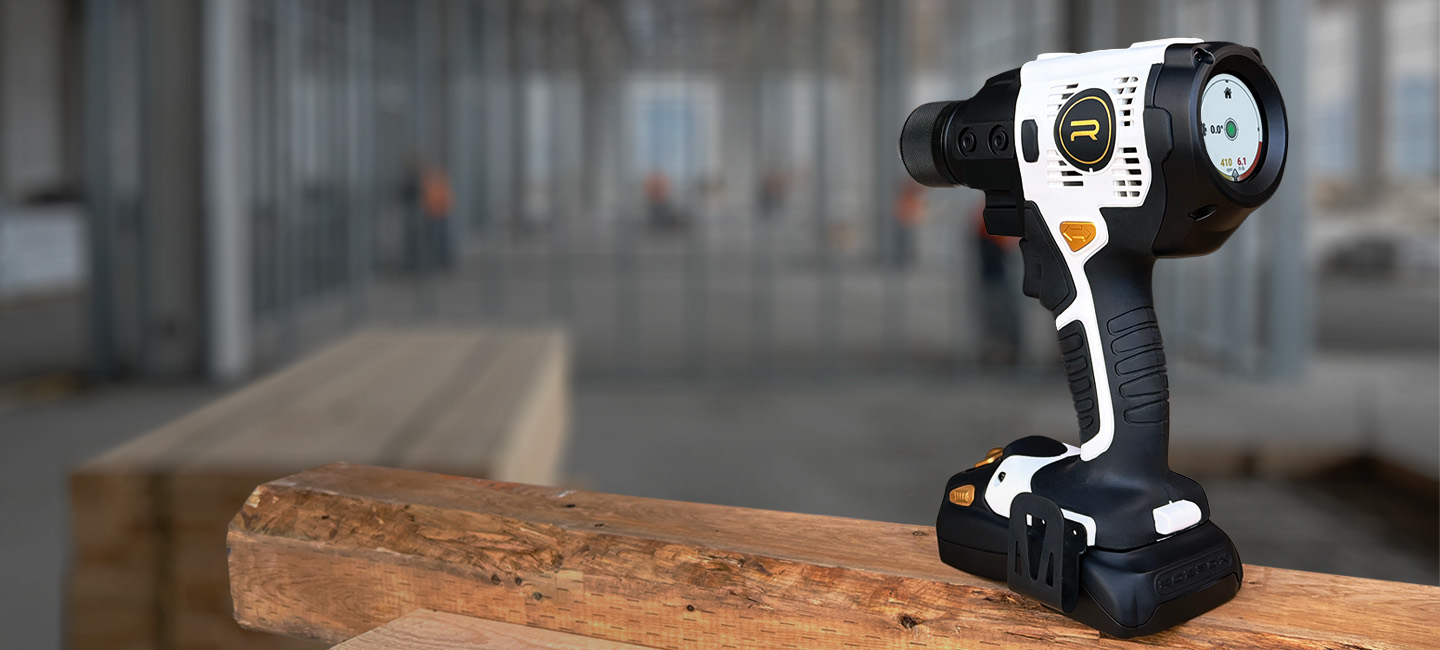 Power tool resting on wooden beams in a construction site.