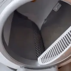 A hand removing lint from a dryer filter.