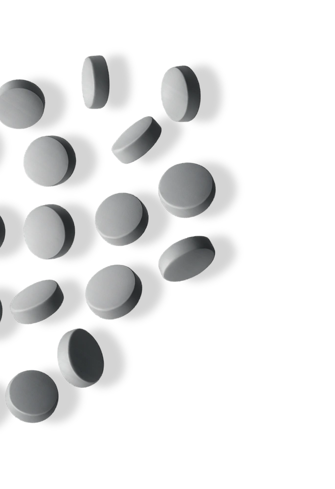 Several grey, round tablets are scattered on the left side of a white background.