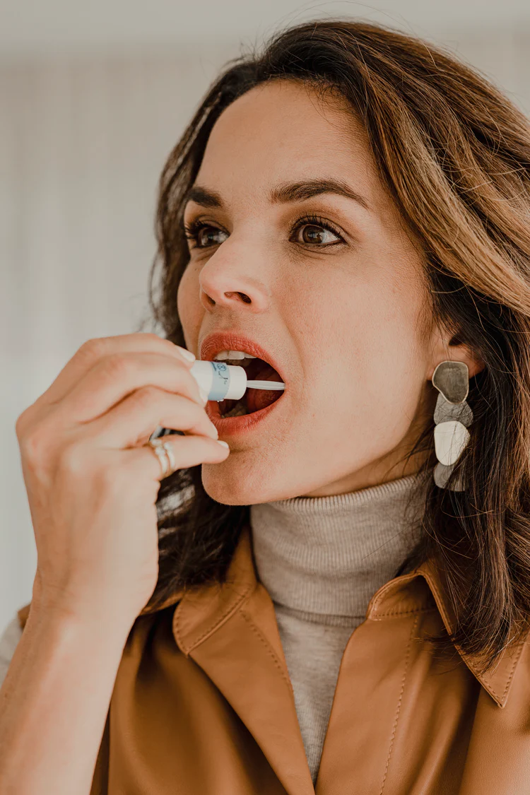 Woman applying a lip product from a tube.