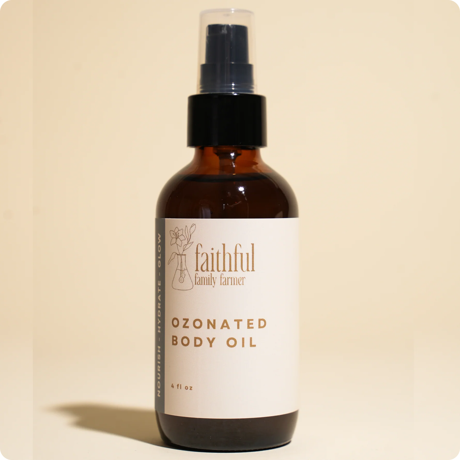 An amber glass spray bottle of Faithful Family Farmer Ozonated Body Oil on a cream background.