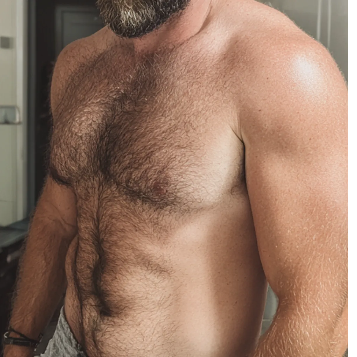 Bearded man with a hairy chest and muscular build. 