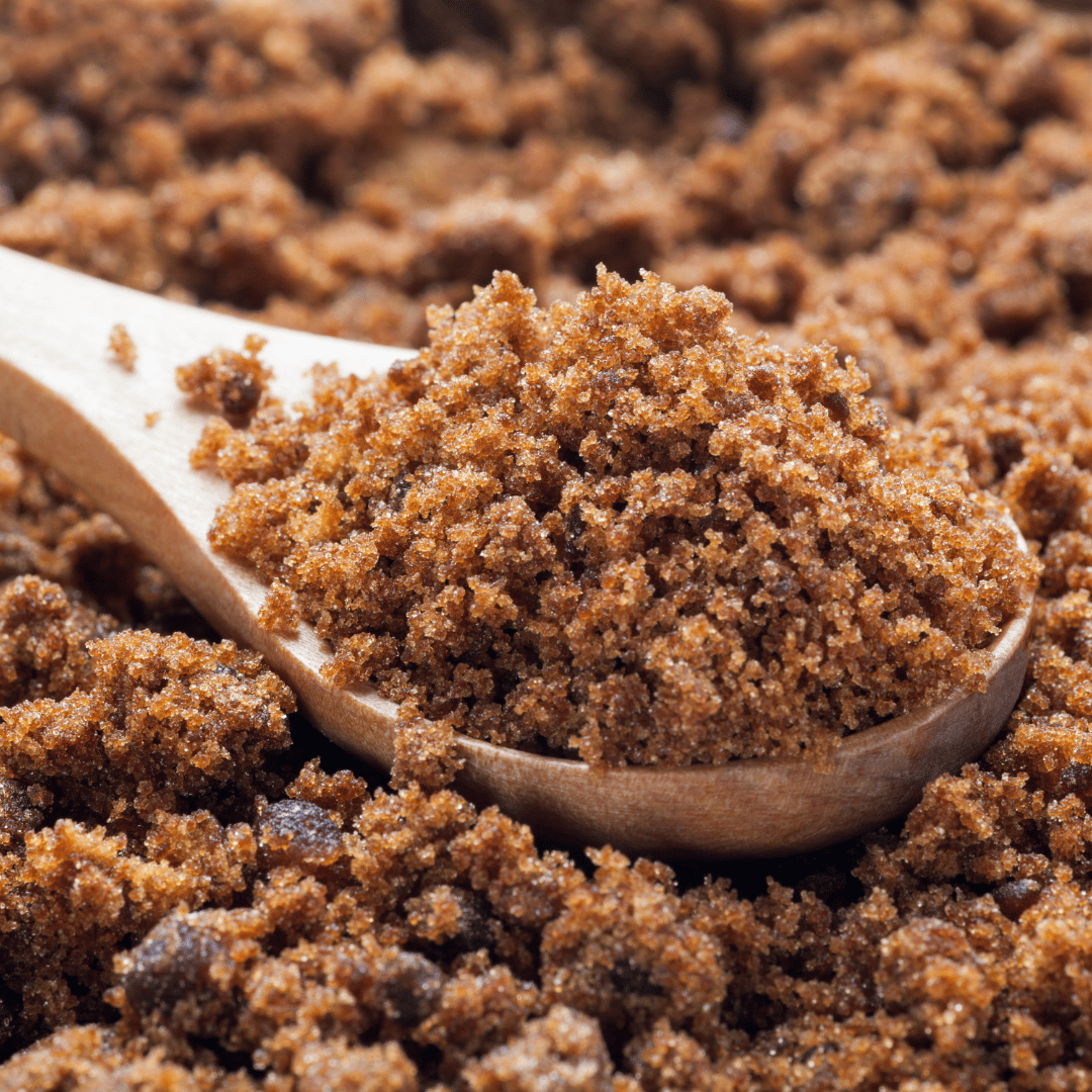 Close-up of brown sugar in a wooden spoon.