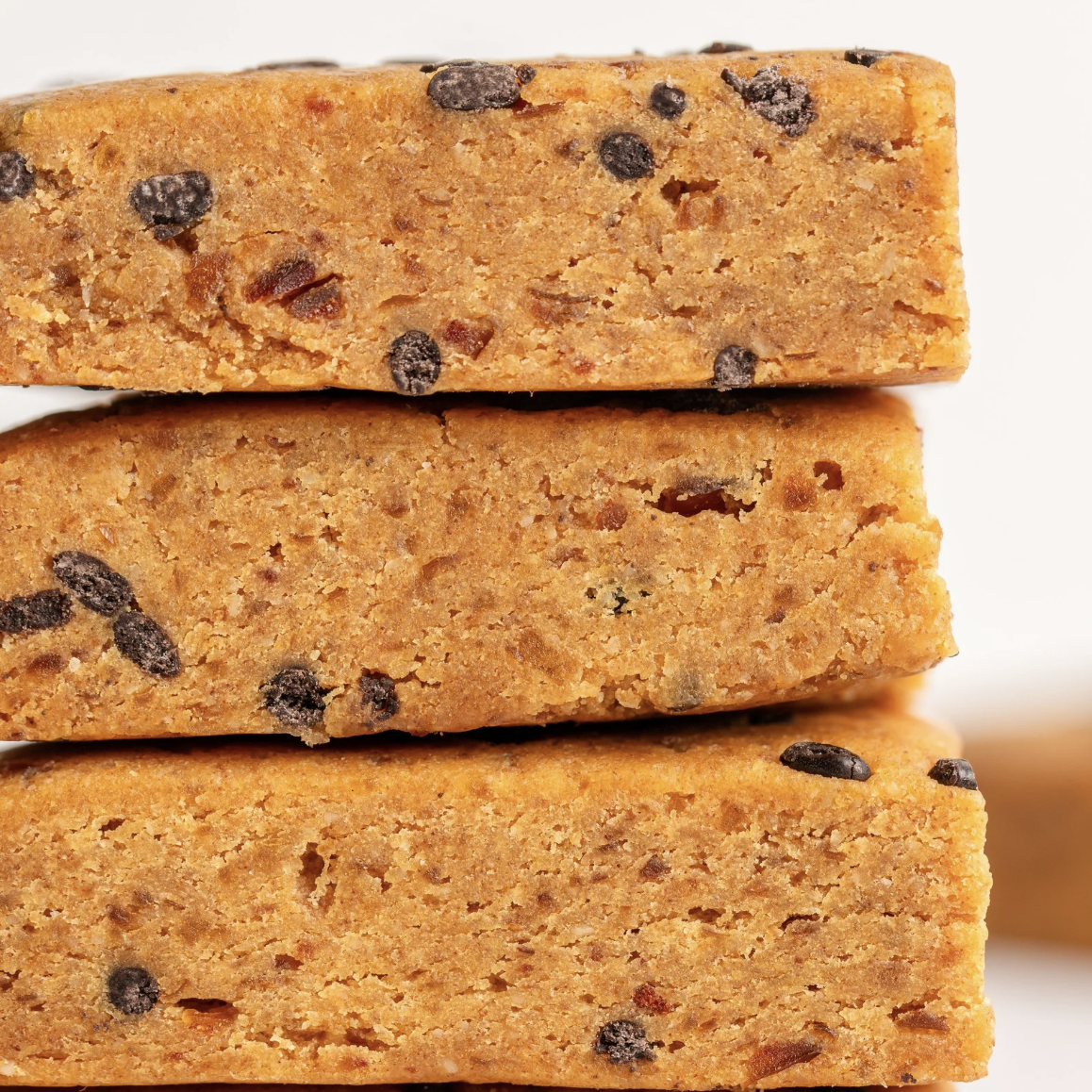 A single palm leaf in a clear glass of water on a white background.