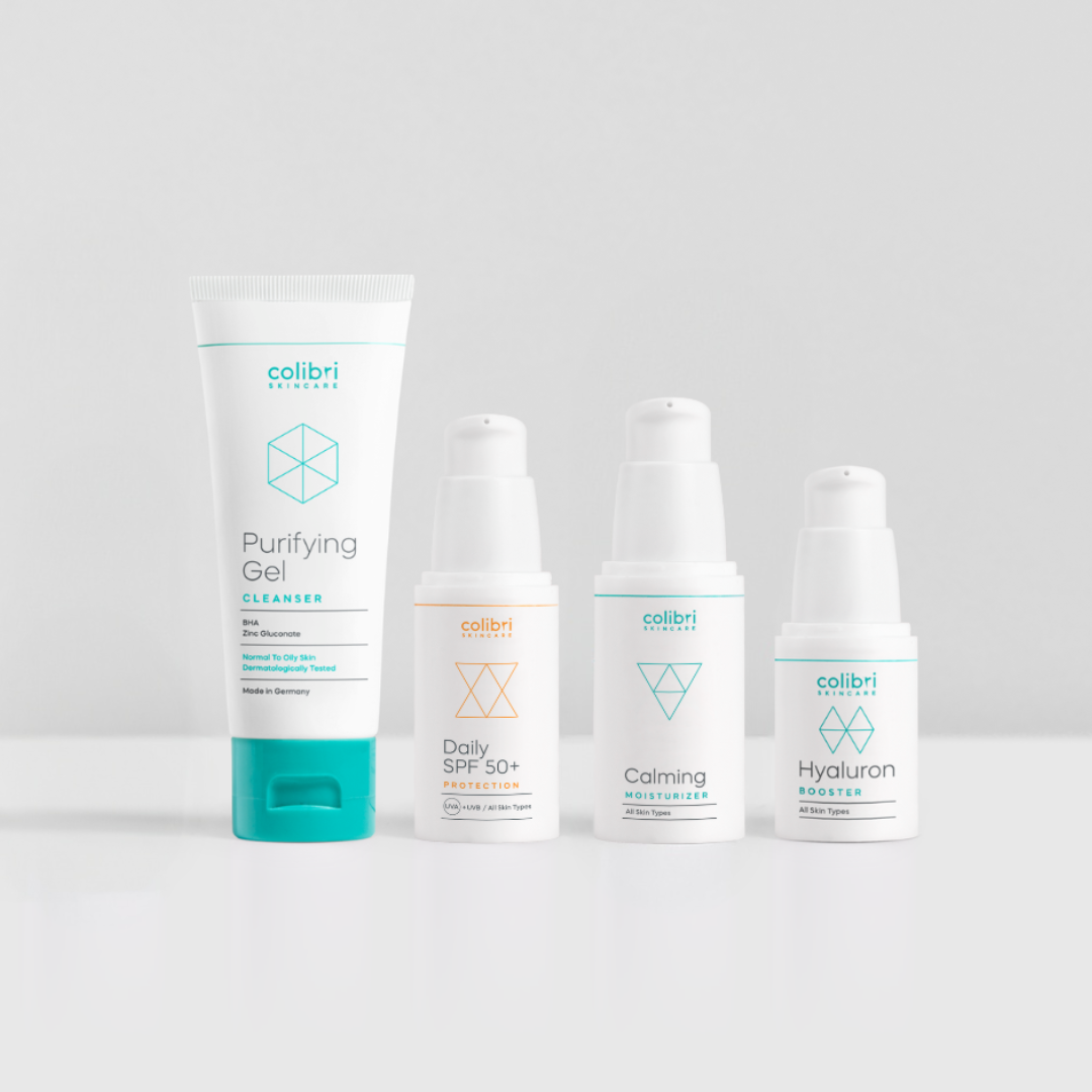 Four skincare product bottles and tubes on a white background.