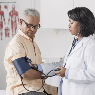 Doctor checking patient's blood pressure with a sphygmomanometer.