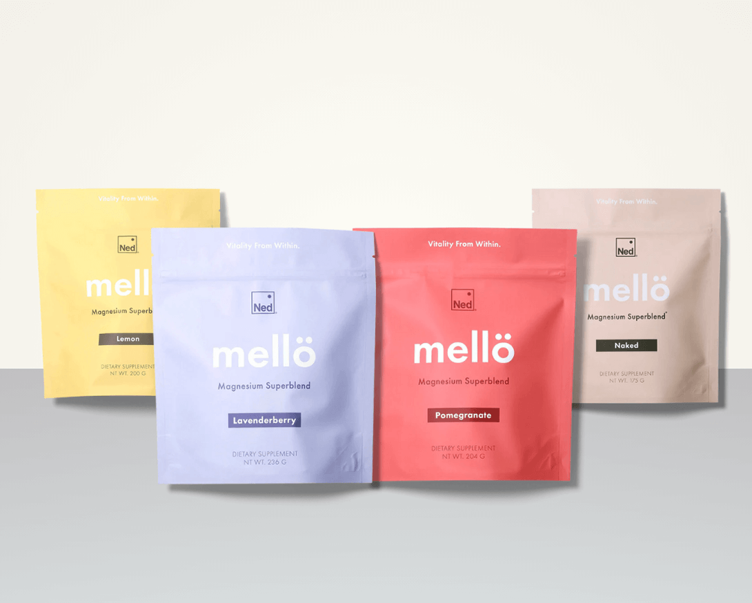 Four colorful 'Mellö' magnesium superblend bags in various flavors on a neutral background.