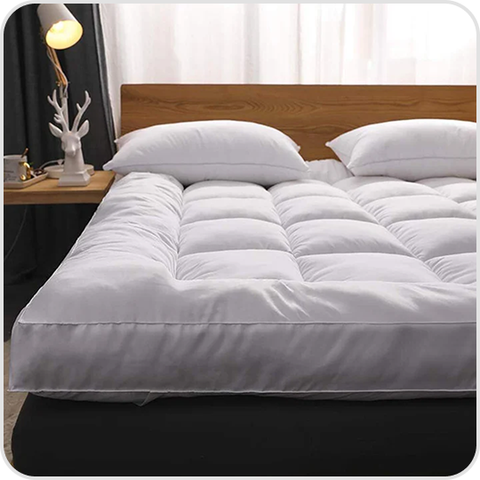 A neatly made bed with a white comforter and two pillows.