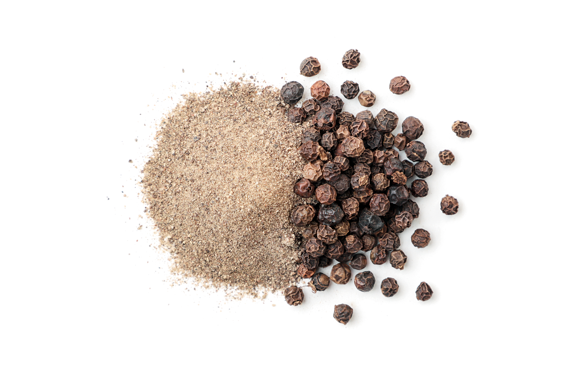 Ground black pepper and whole peppercorns on a white background.