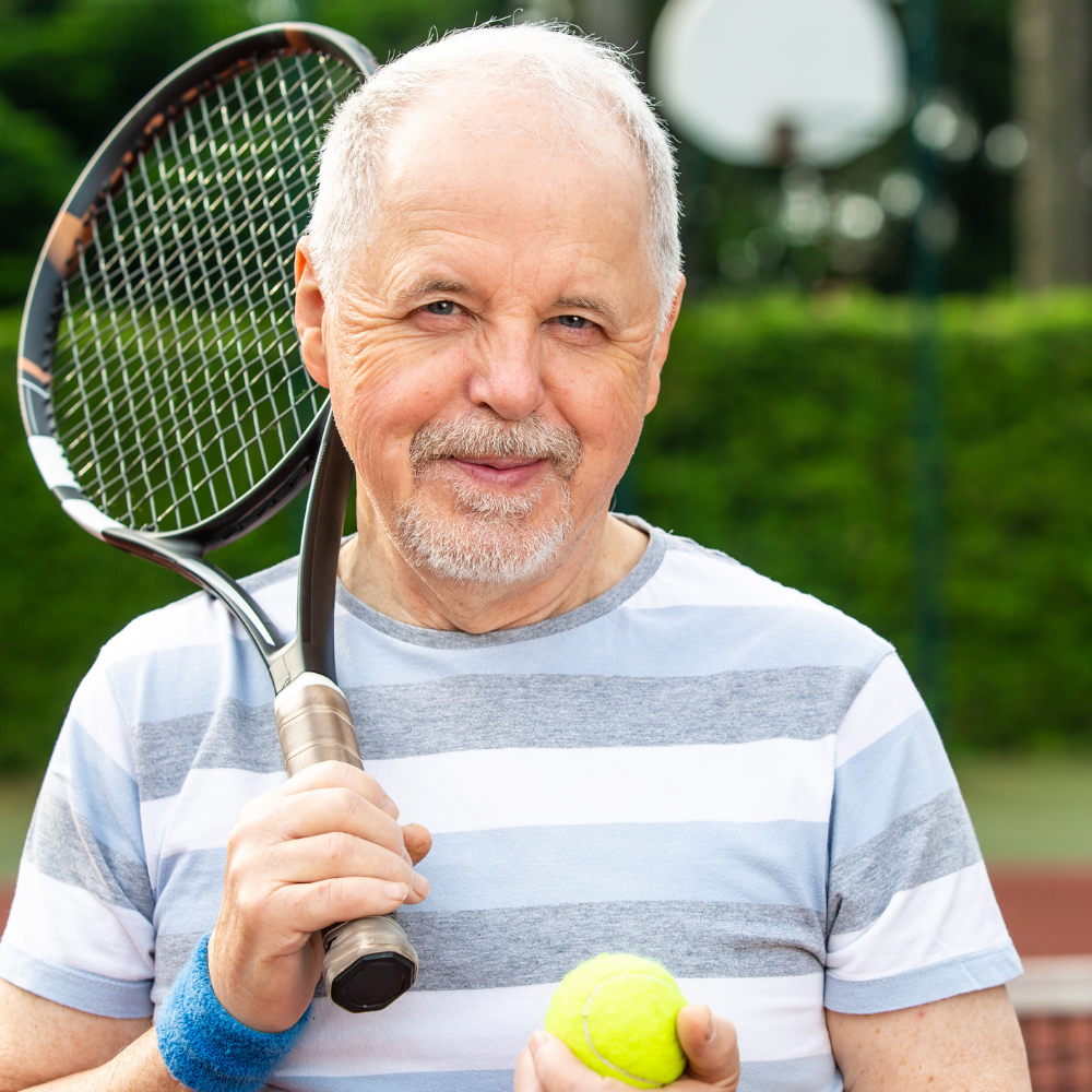 Man holding a tennis racket and ball on a court.