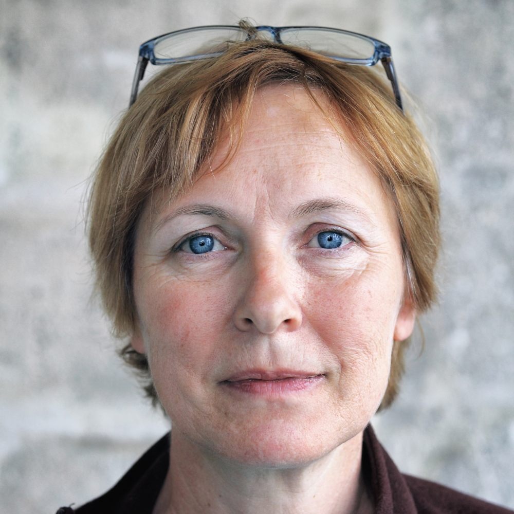 Close-up of a person with short hair and glasses on their head.