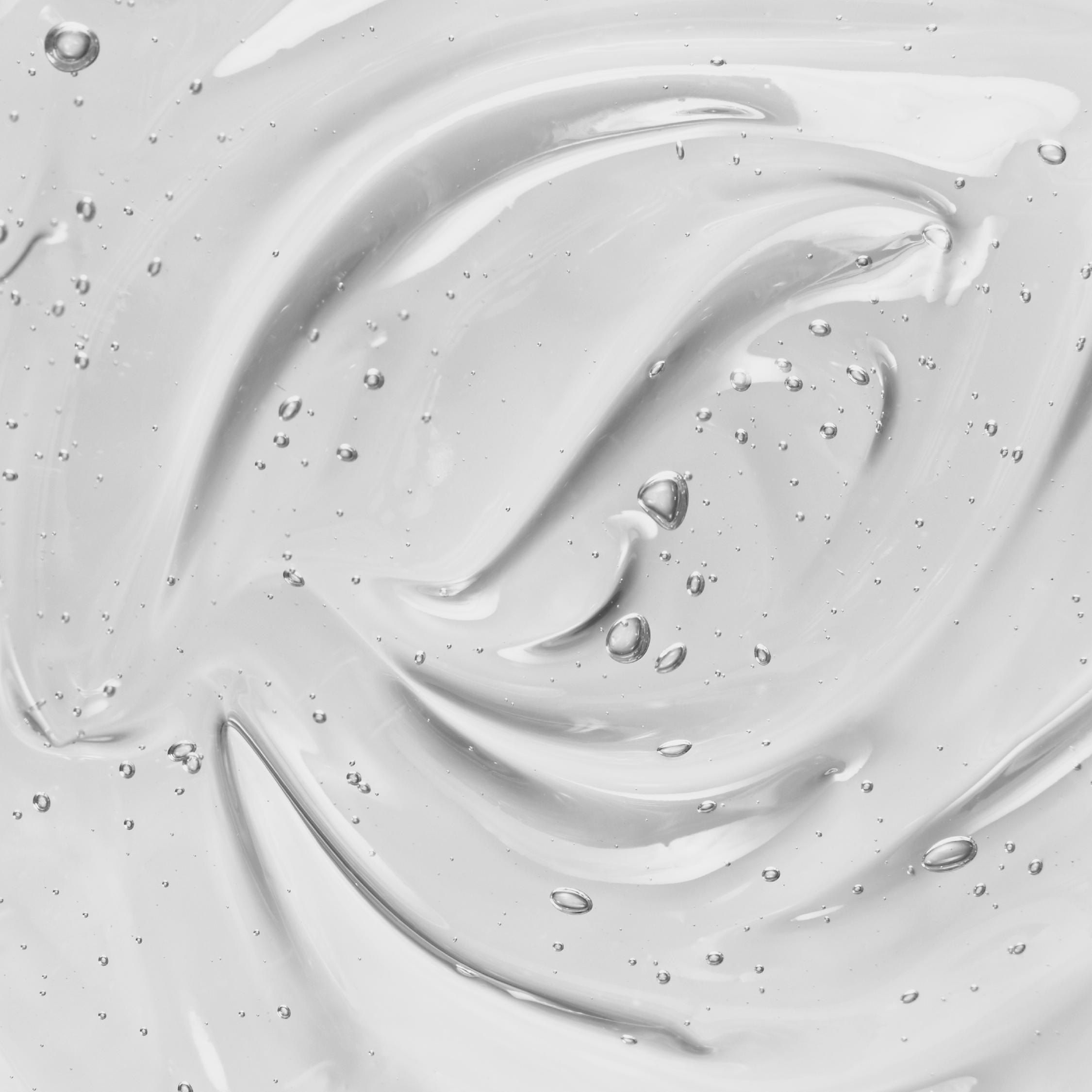 Close-up of clear gel with bubbles and smooth swirls.