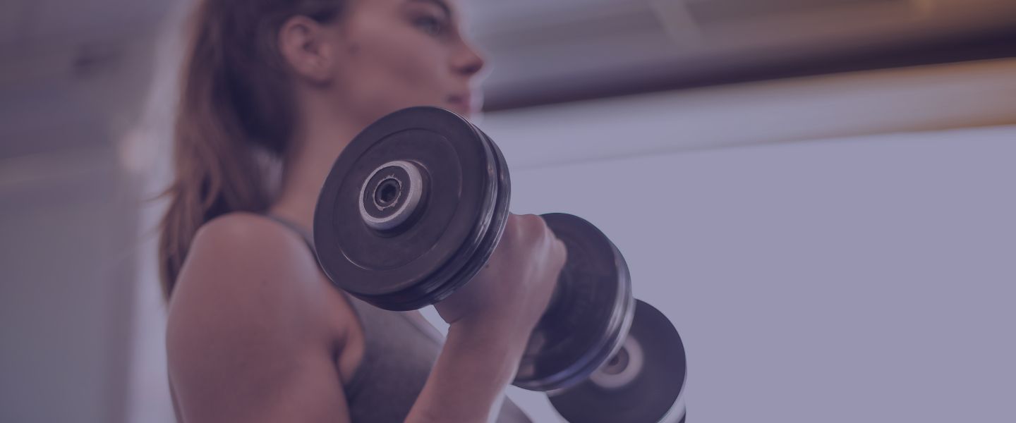 Person lifting a dumbbell in a gym setting.