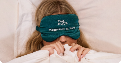 Person in bed with a sleep mask reading 'Free Soul Magnesium at work.'