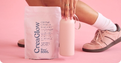 Person holding a pink bottle next to a CreaGlow product bag on a pink background.