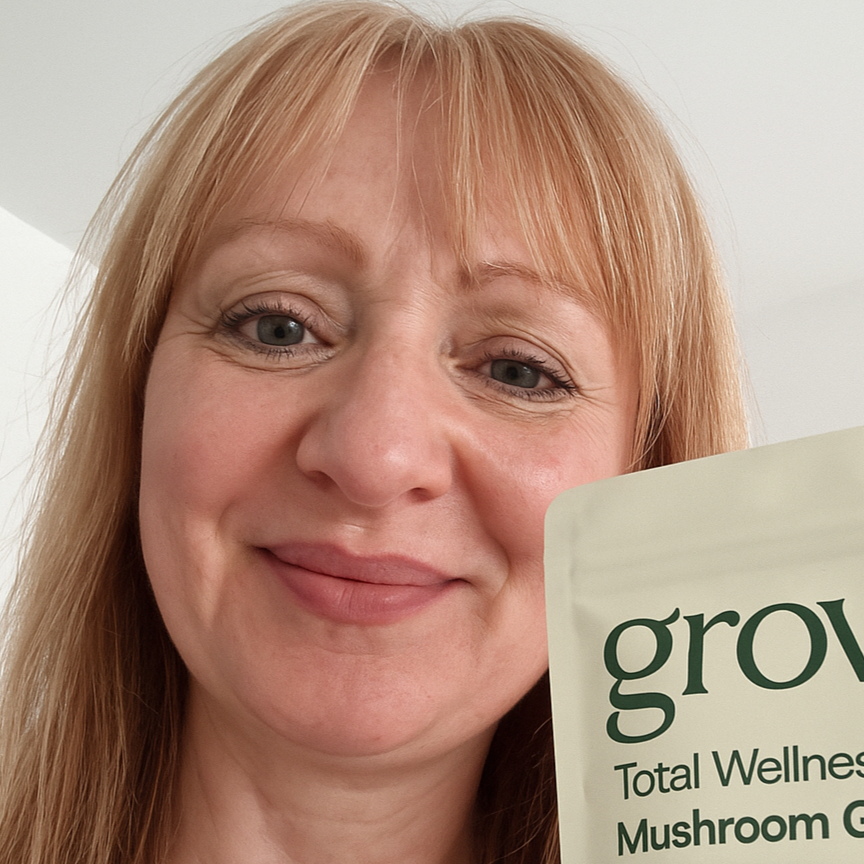 Woman smiling while holding a pouch of Grova Mushroom Gummies, showing satisfaction with the product.