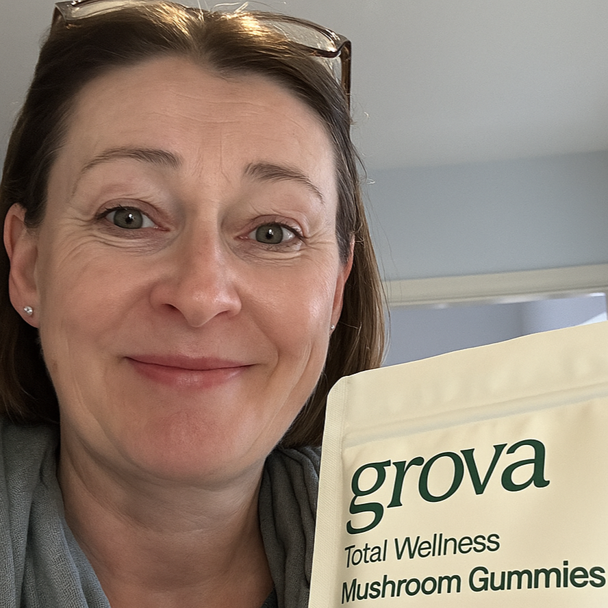 Person smiling, holding a package labeled 'grova Total Wellness Mushroom Gummies.'