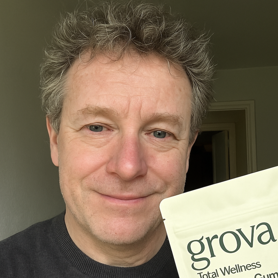 Middle-aged man smiling with a Grova Mushroom Gummies pack, endorsing the product.