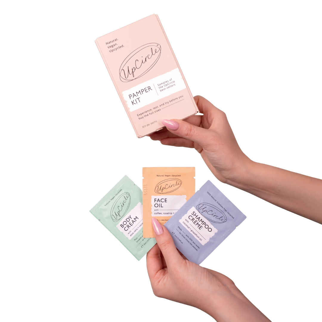 Hands holding skincare samples labeled 'UpCircle Pamper Kit.'