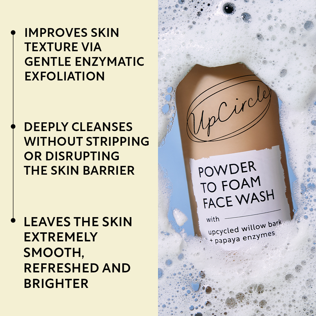 An UpCircle Powder to Foam Face Wash bottle surrounded by foam, next to a list of product benefits.