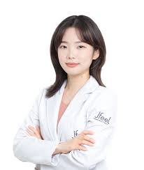 Person in a white lab coat with arms crossed, smiling.