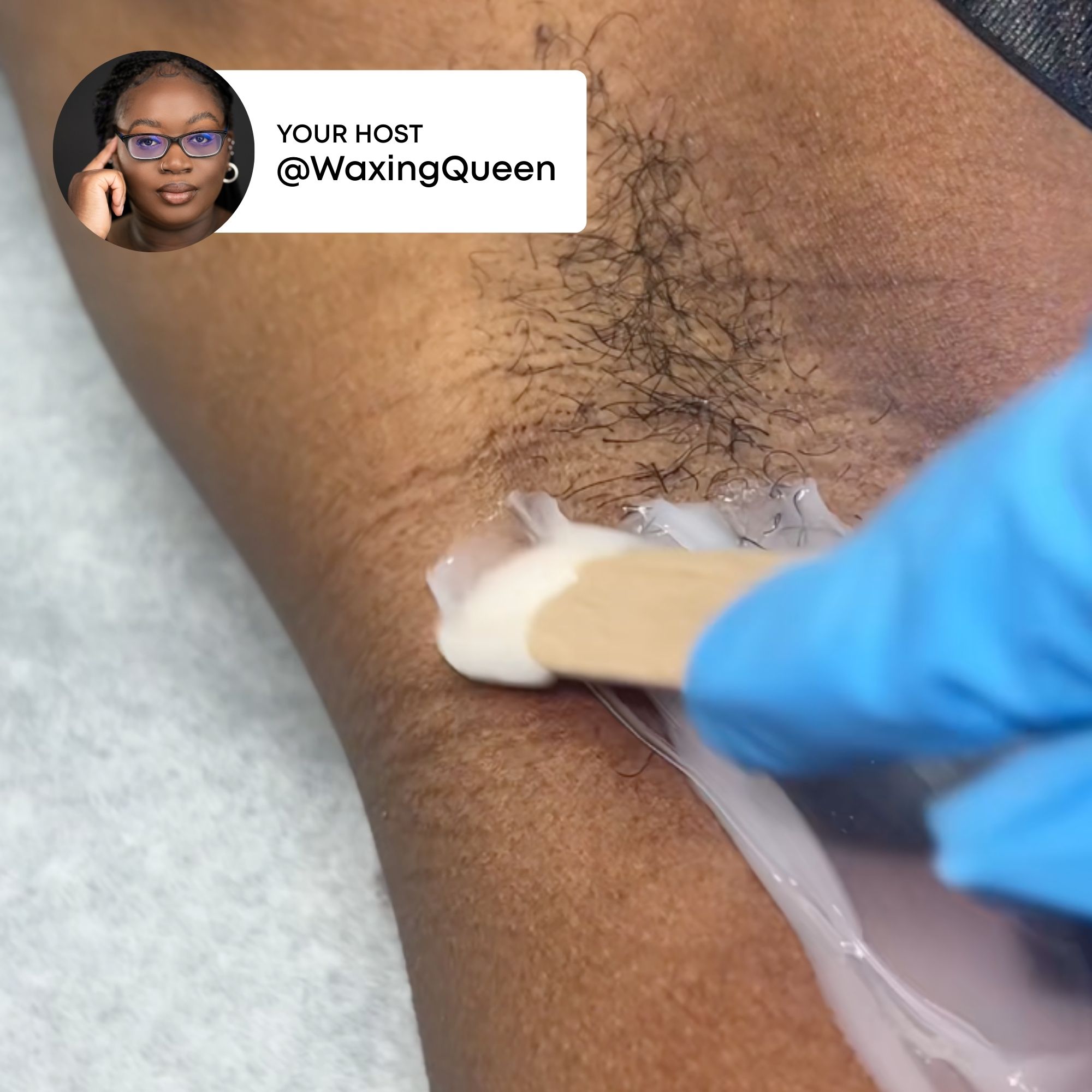 A person applying wax with a spatula on skin.