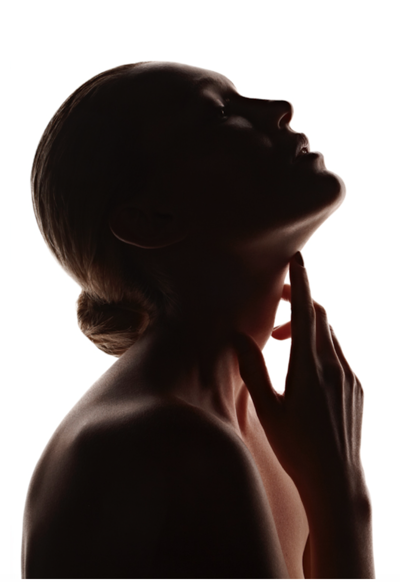 Silhouette of a woman with hand on neck, head tilted back.