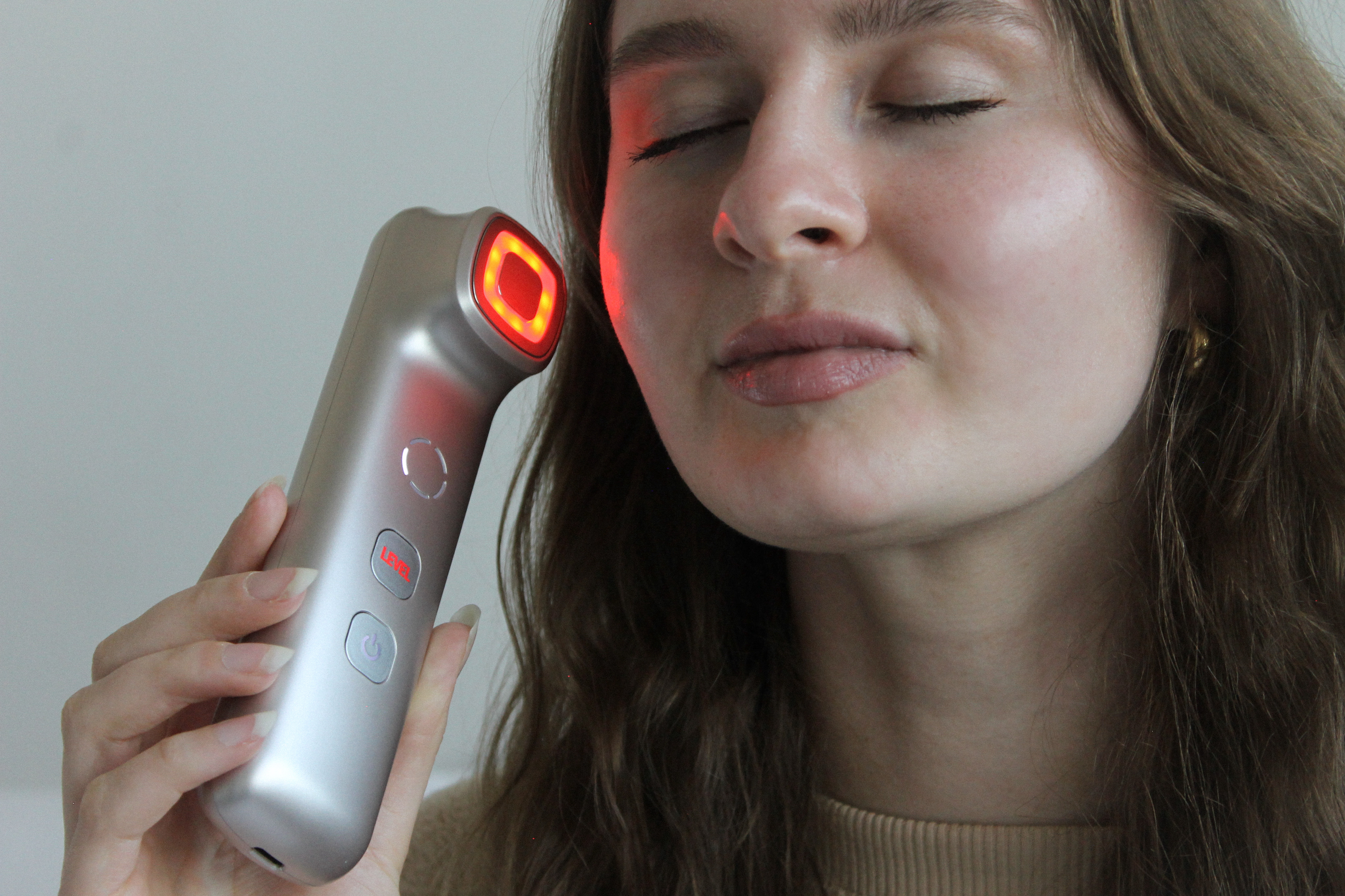 Person using a device emitting red light on the face.