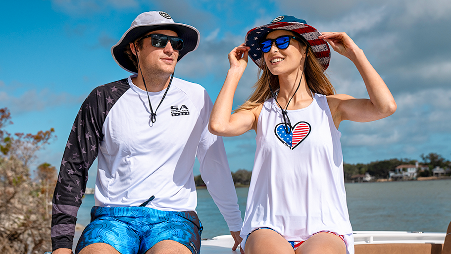 Two people wearing hats and sunglasses sitting on a boat.