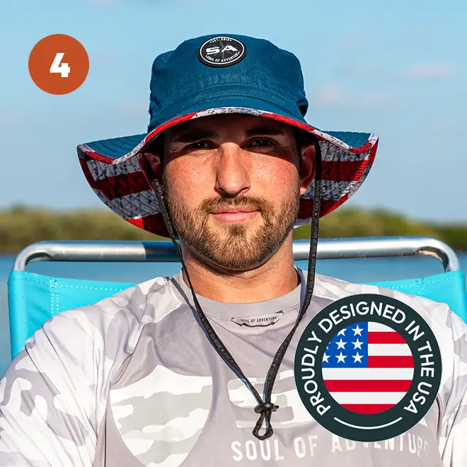 Man wearing a blue hat with USA design, sitting outdoors.