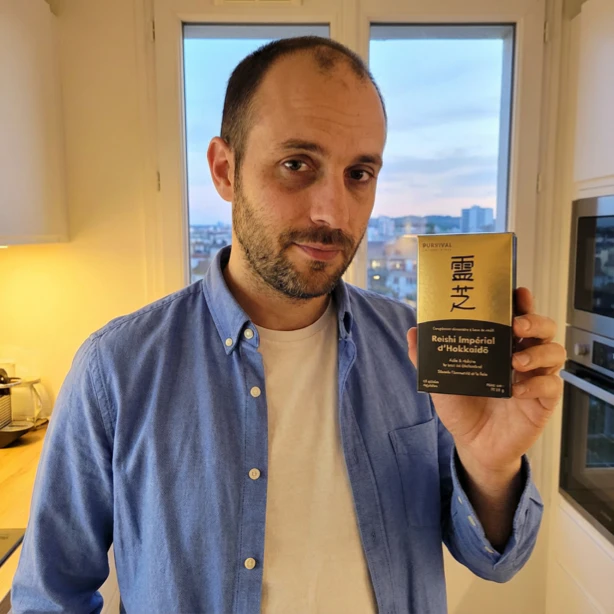 Person holding a box with Japanese text in a bright room.