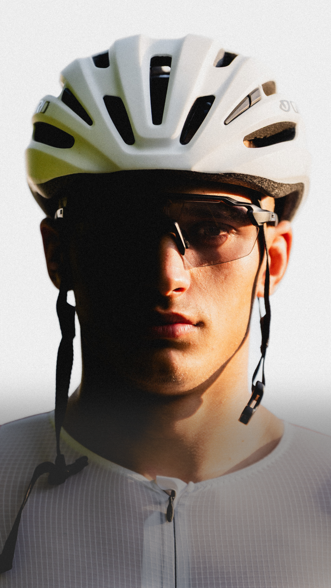 Close-up of a person wearing a white helmet and sunglasses.