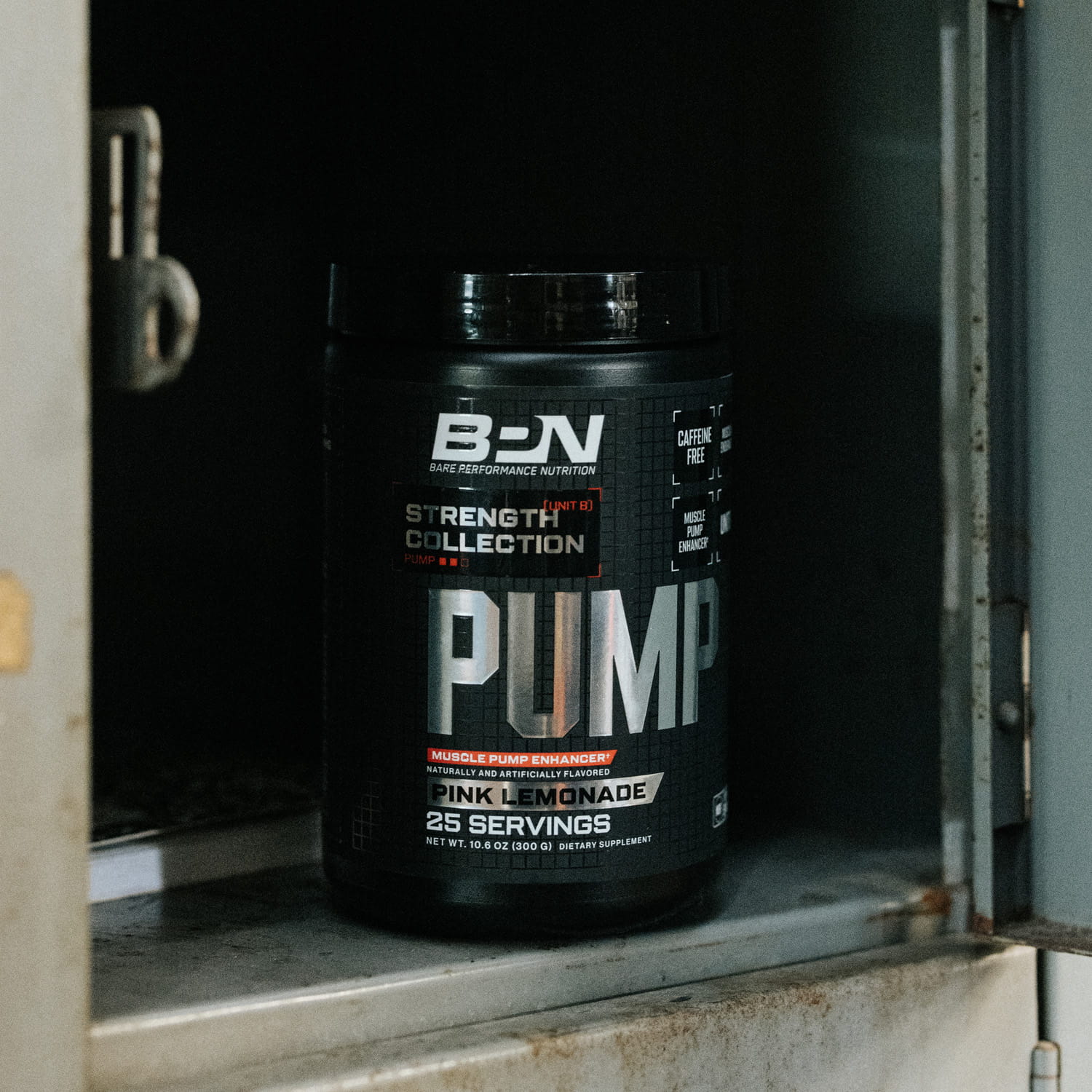 A black tub of BPN Pump supplement in Pink Lemonade flavor sitting inside a metal cabinet.