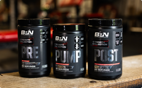 Three black tubs of B-N workout supplements—PRE, PUMP, and POST—lined up on a wooden surface.