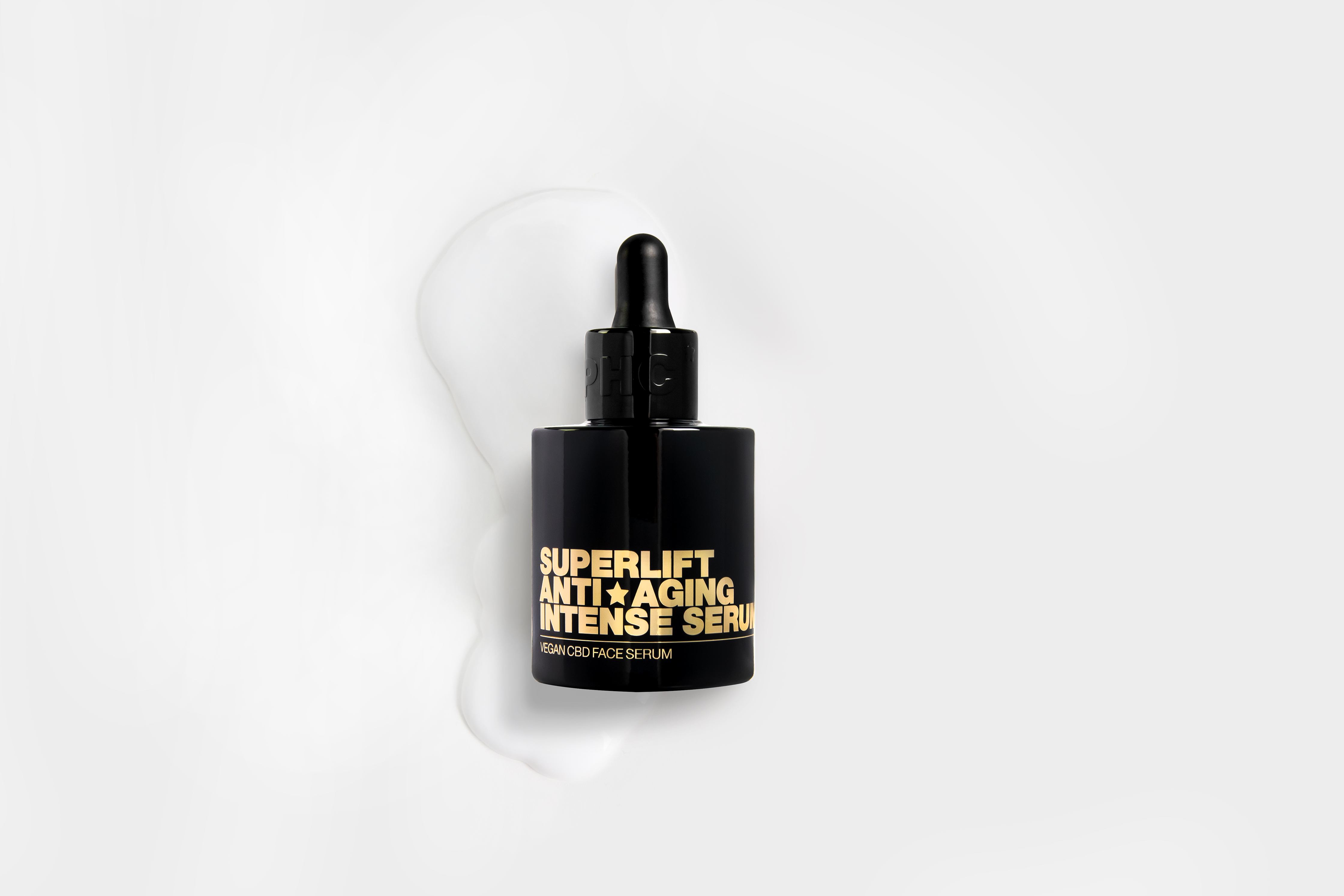 Black bottle of anti-aging serum with dropper on white background.