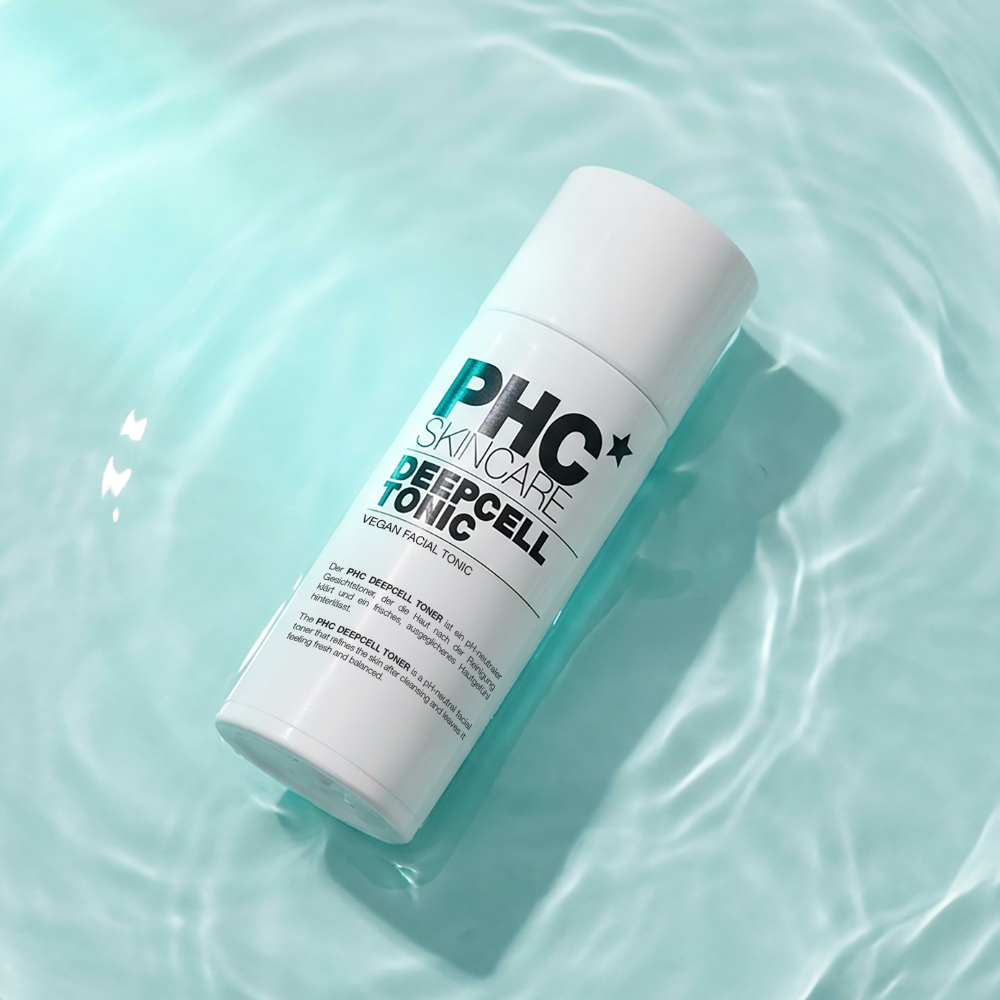 A white bottle of PHC Skincare Deepcell Tonic resting in light blue, rippling water.