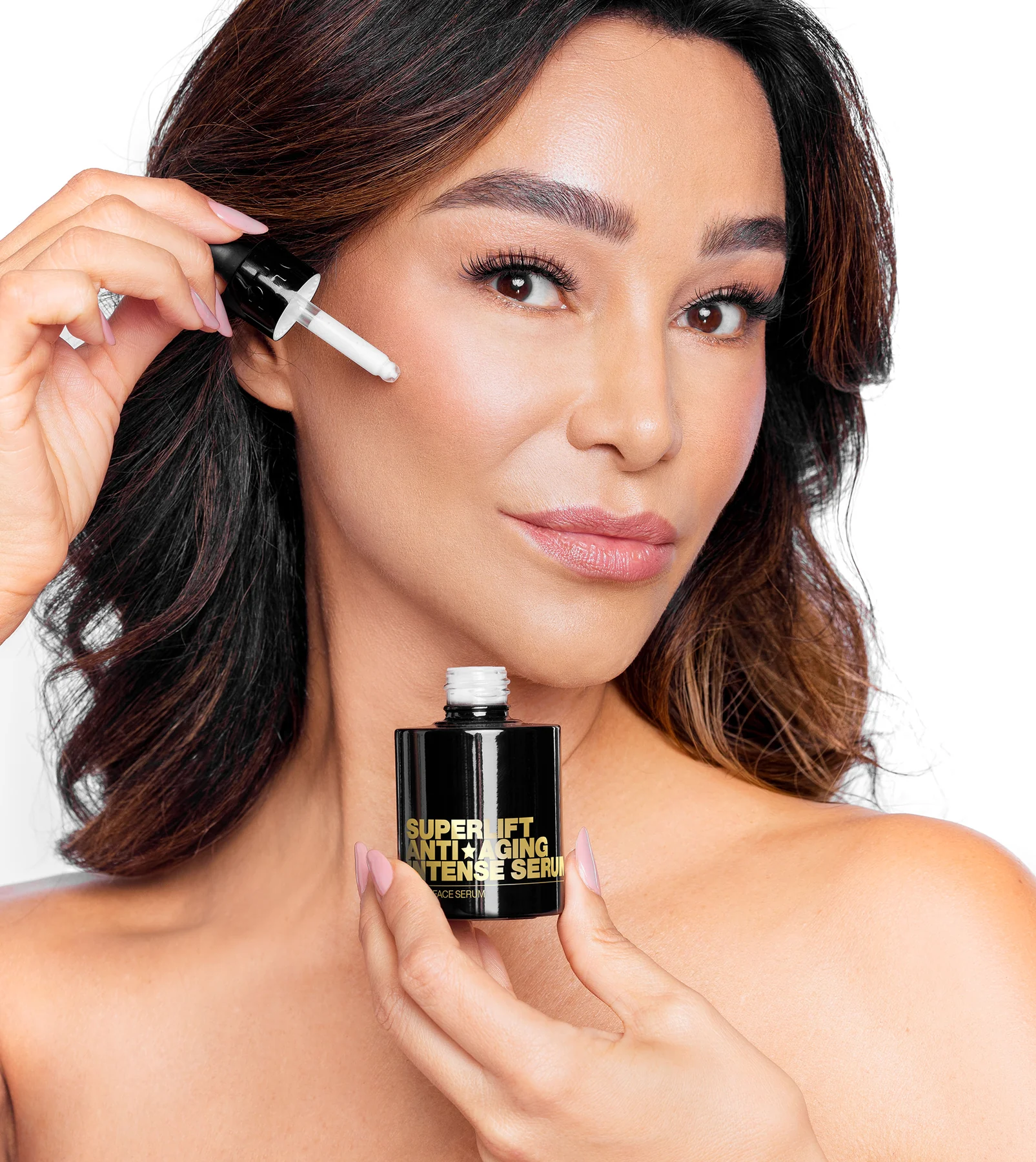 Person applying serum to face with dropper.