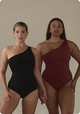Two people wearing one-shoulder swimsuits, one in black and one in maroon.