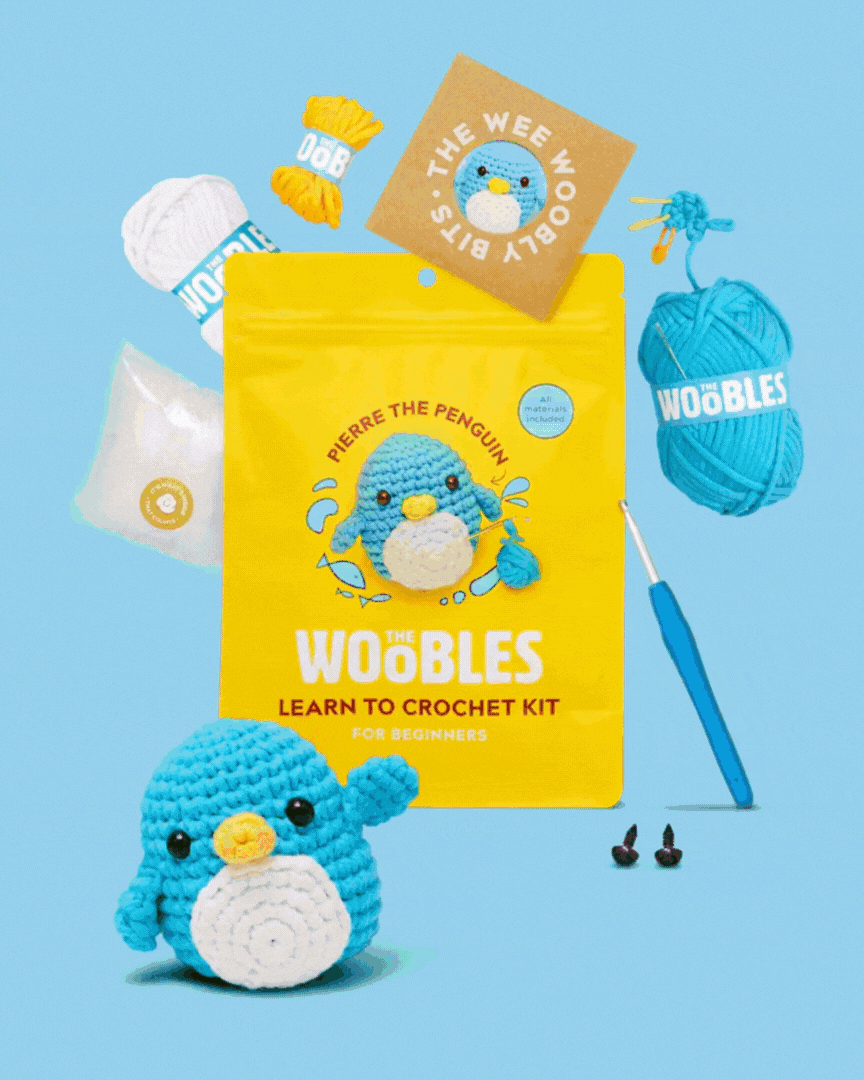 Crochet kit with yarn, hook, and penguin design on a blue background.