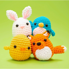 Four crocheted animal toys on a green background.