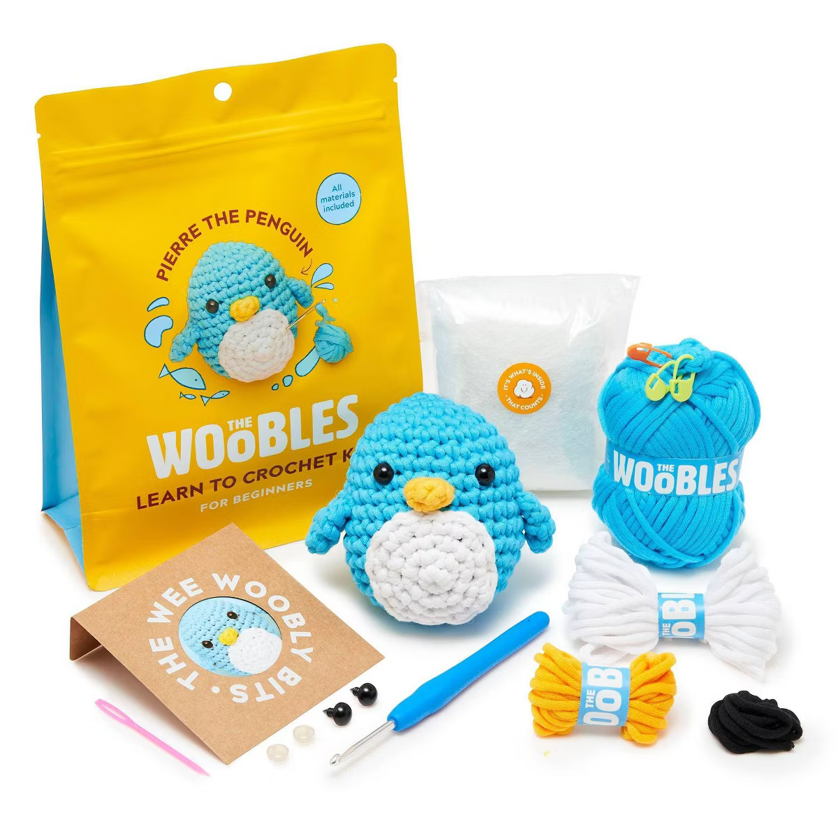 Crochet kit with blue penguin, yarn, hook, and instructions for beginners.