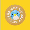 Crocheted blue penguin in brown circle, yellow background, 'THE WEE WOOBLE BITS' text.