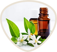 Brown glass bottle with white flowers and green leaves.