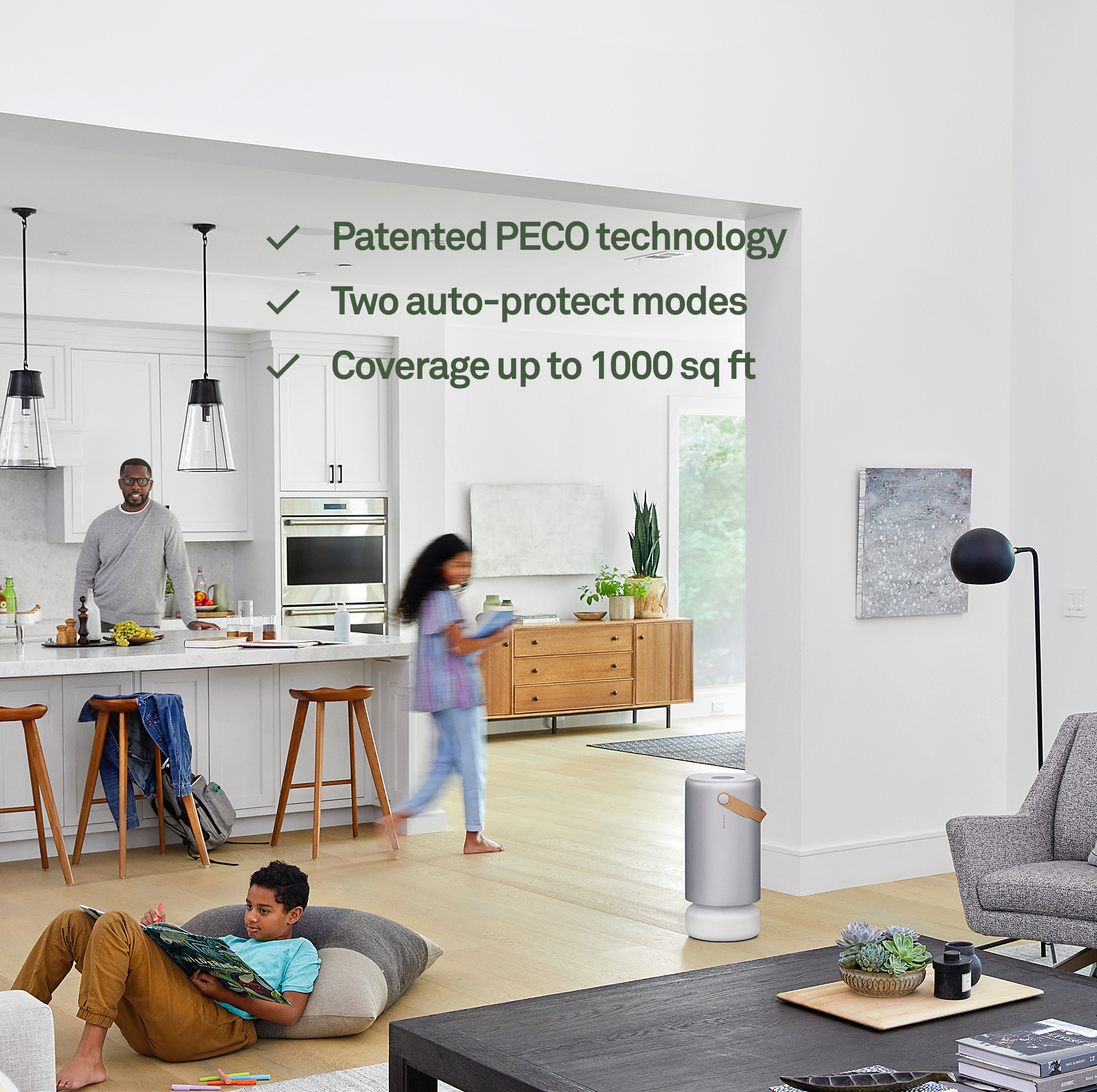 Family in a modern living room with air purifier and kitchen in background.