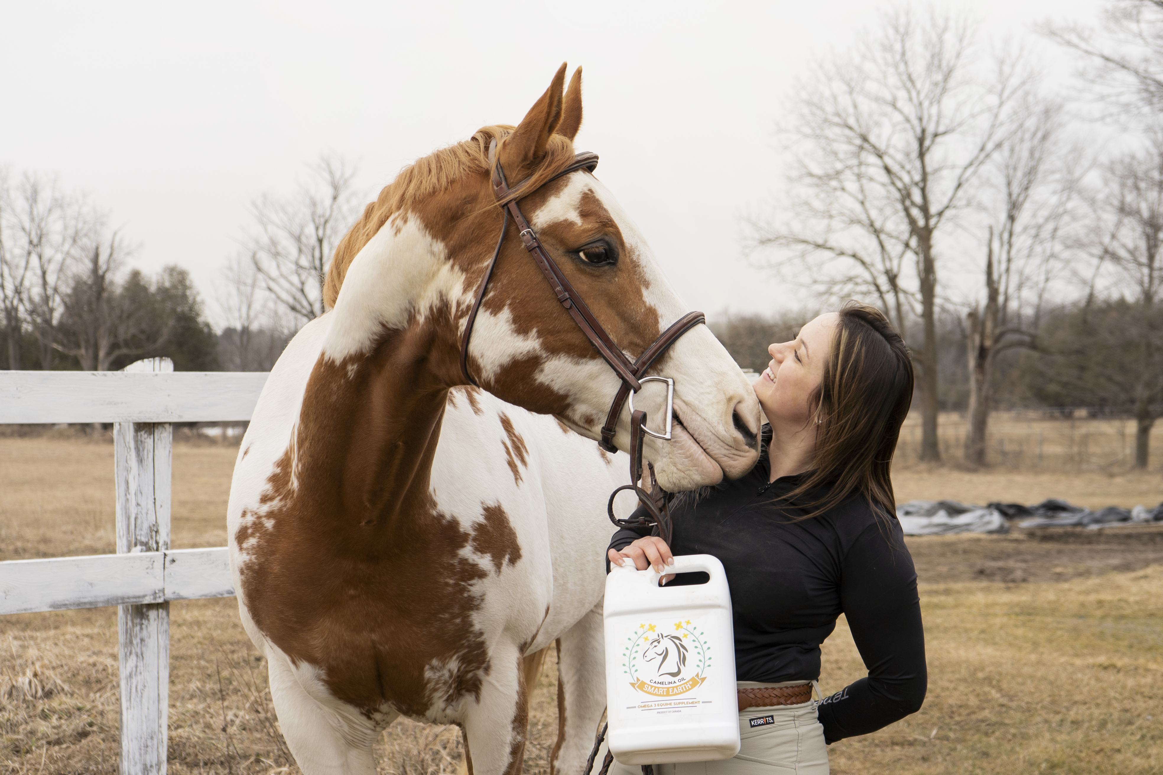 Woman with a paint horse holding Smart Earth Camelina product
