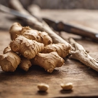 Fresh ginger root on a wooden surface with a rustic background.