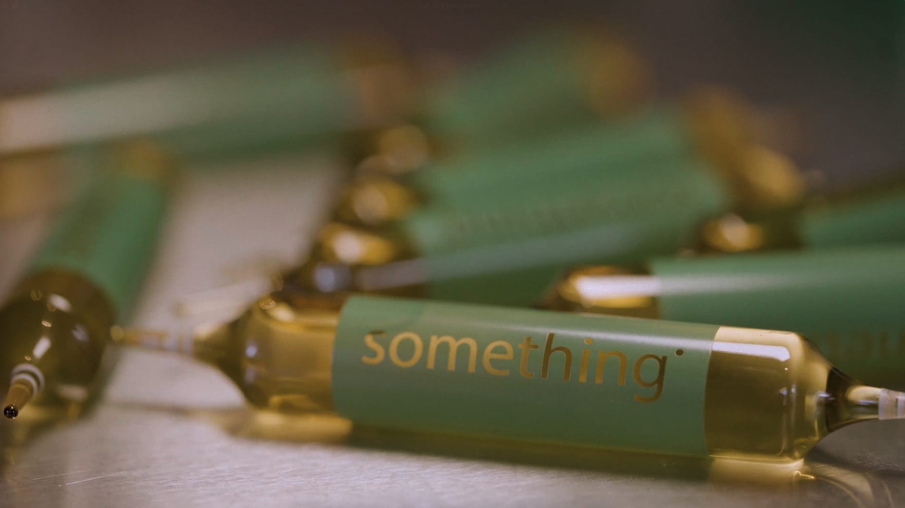 Close-up of green syringes with 'something' written on them.