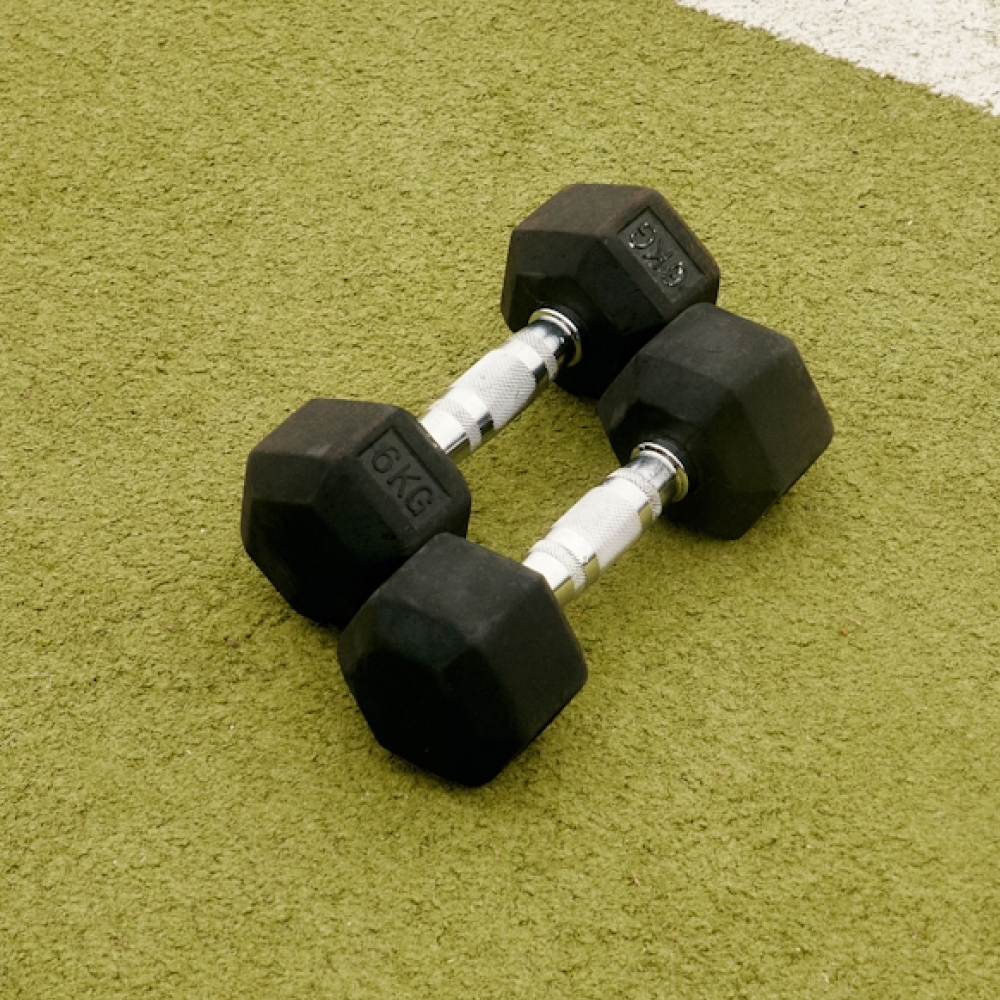 Two 6kg dumbbells on green exercise mat.